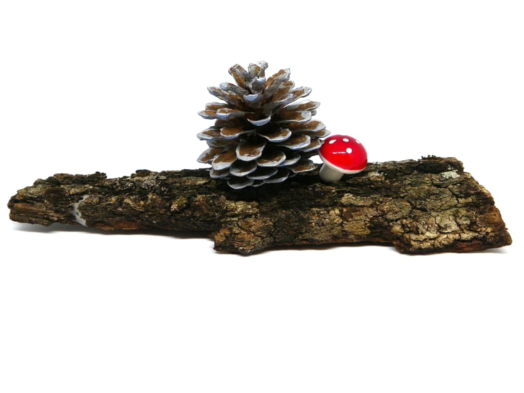 centro de mesa hecho con un trozo de corteza una piña y seta decorativa adornos para navidad
