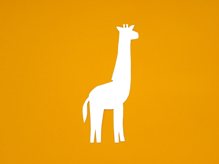 cartulina de color naranja claro y plantilla de una jirafa para hacer marcapaginas