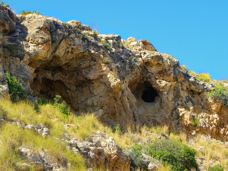 vista de un pico con concavidad y cueva en el barranco de la tia amalia en la sierra de santa pola
