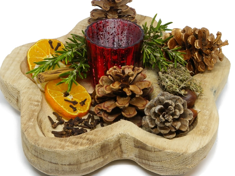 centro de mesa aromatico hecho con un bol de madera especias y hierbas aromaticas fruta seca piñas y otros elementos
