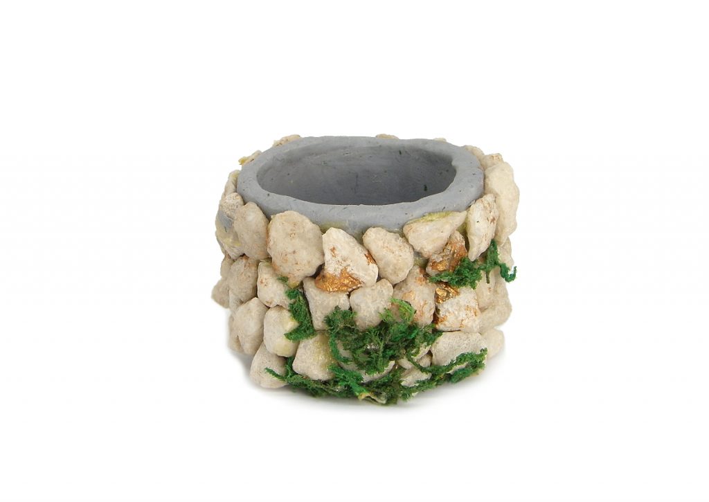 entubado del pozo en miniatura hecho con plastilina y pequeñas piedras incrustadas