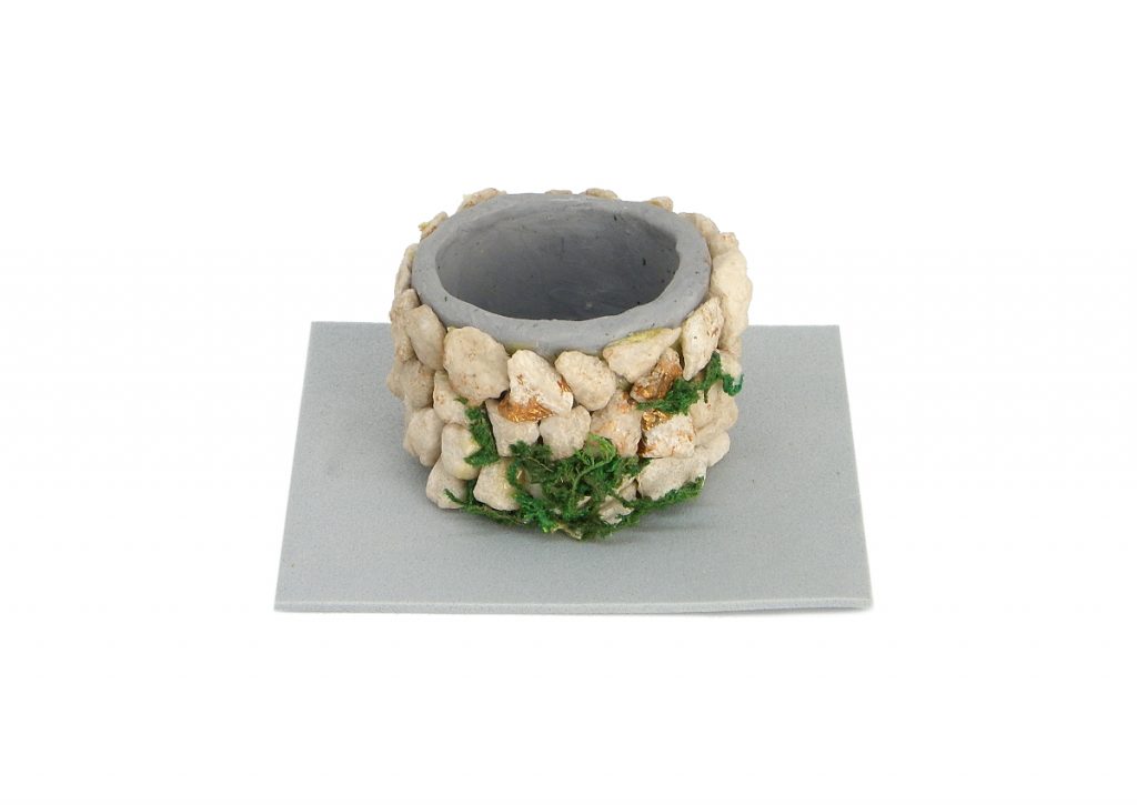 entubado del pozo en miniatura hecho con plastilina y piedras pequeñas con una base de goma eva