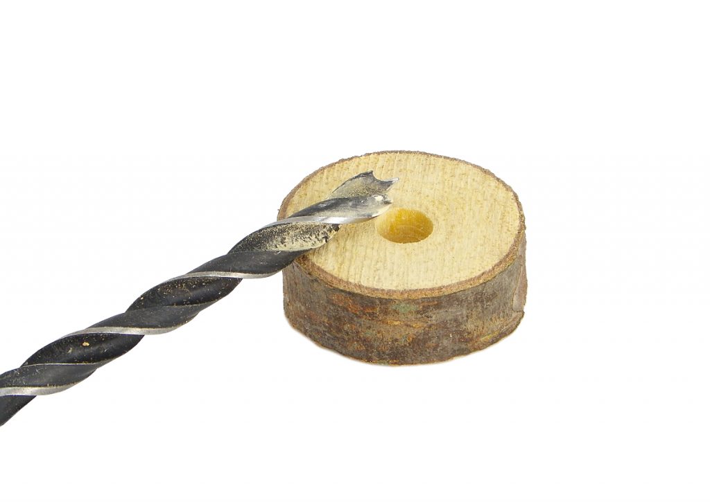 rodaja de madera de pino perforada y broca para madera