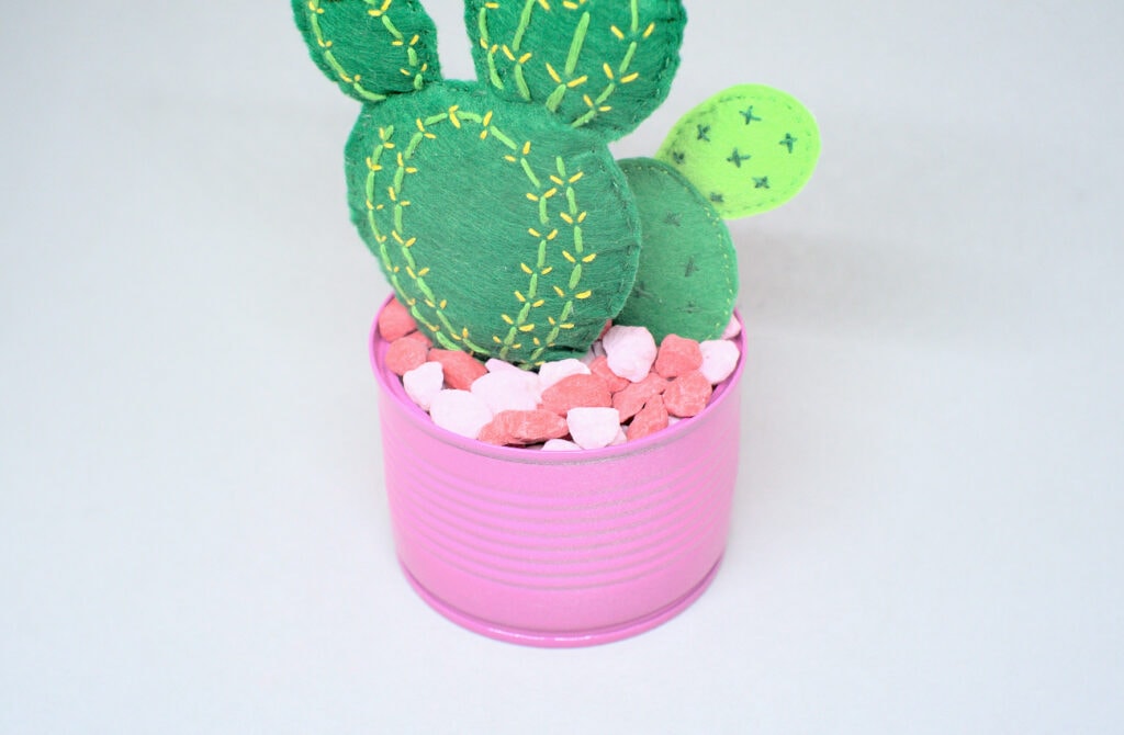 maceta rellena con piedras de colores y cactus de fieltro de colores
