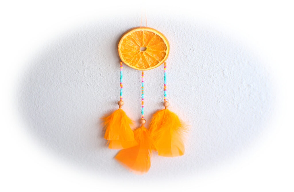 atrapasueños con rodajas de naranja y plumas de colores