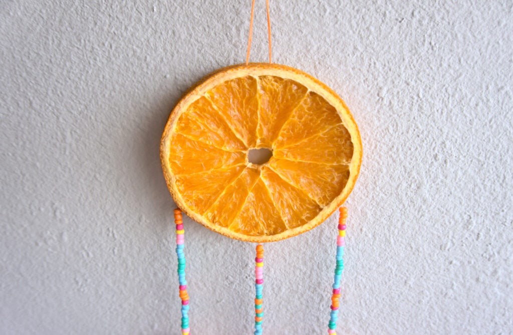 rodaja de naranja seca con tiras de cuentas de colores