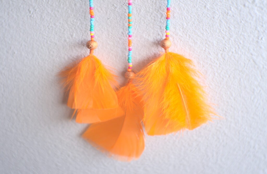 tiras con cuentas y plumas de colores de atrapasueños de naranja