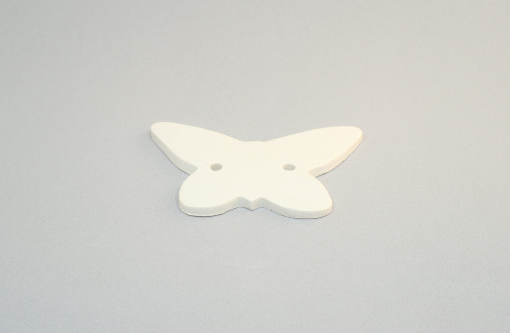 figura de pasta de modelar de una mariposa con dos orificios