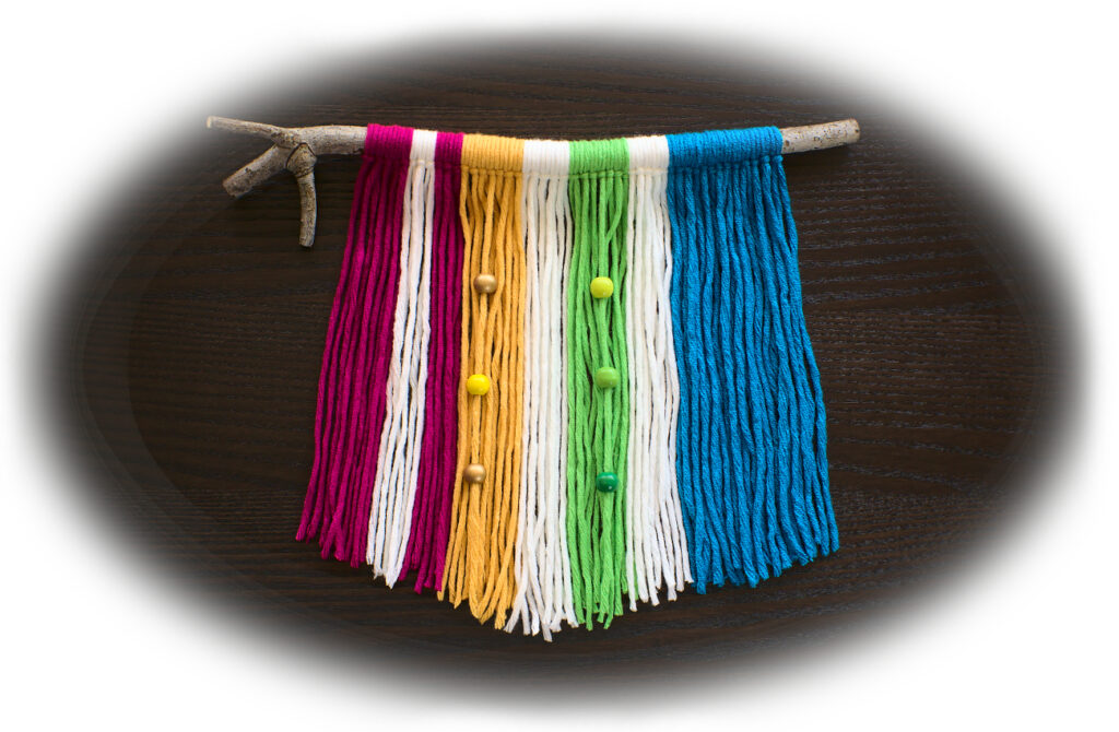 tapiz de pared hecho con lana de colores y una rama seca marco