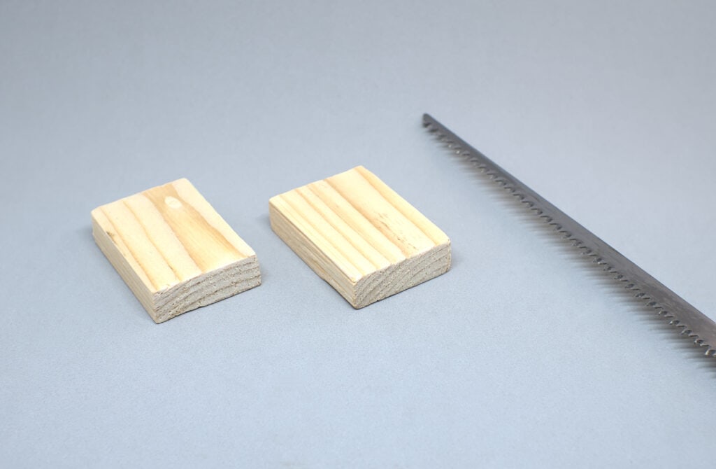 dos piezas de madera de pale serradas con sierra de mano