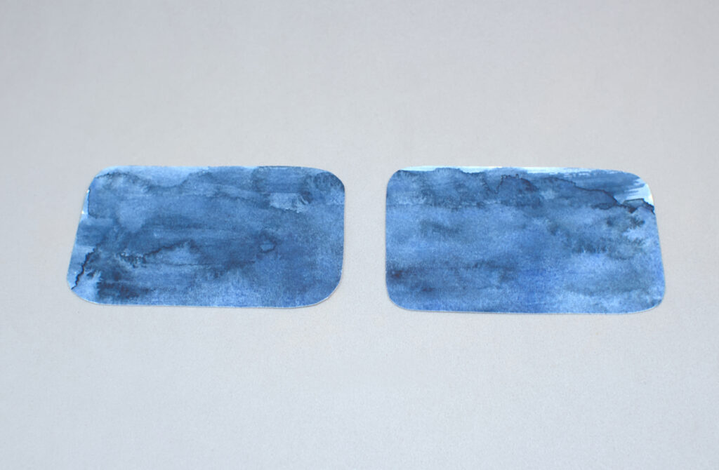 dos piezas de papel de acuarela pintadas de azul añil