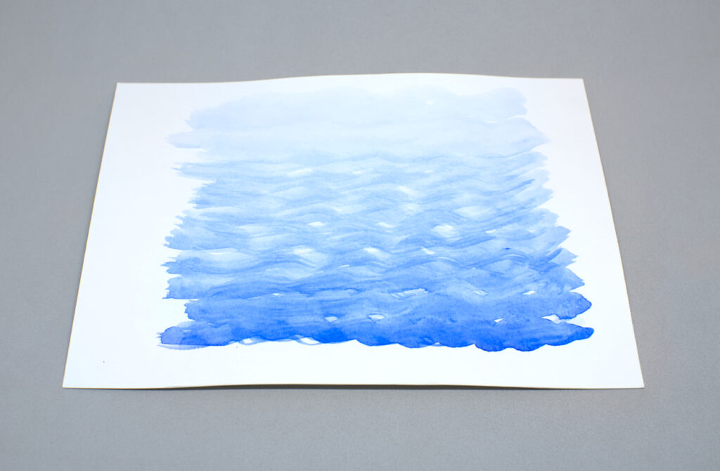 papel de acuarela pintado de color azul diluido