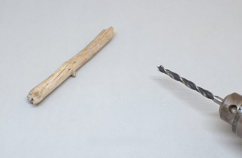 fragmento de madera de deriva y taladro con broca para madera