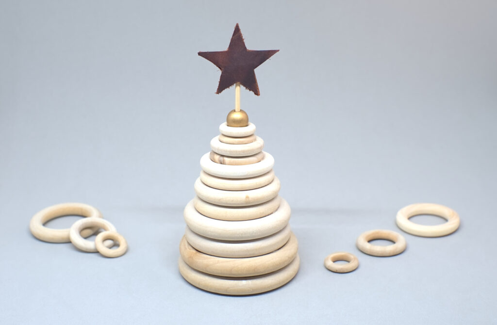 arbol navideño hecho con aros de madera y estrella de cuero