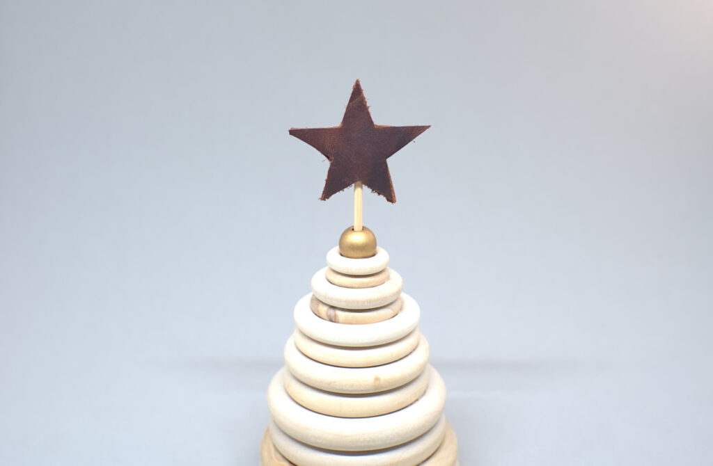 estrella de cuero coronando arbol navideño de madera