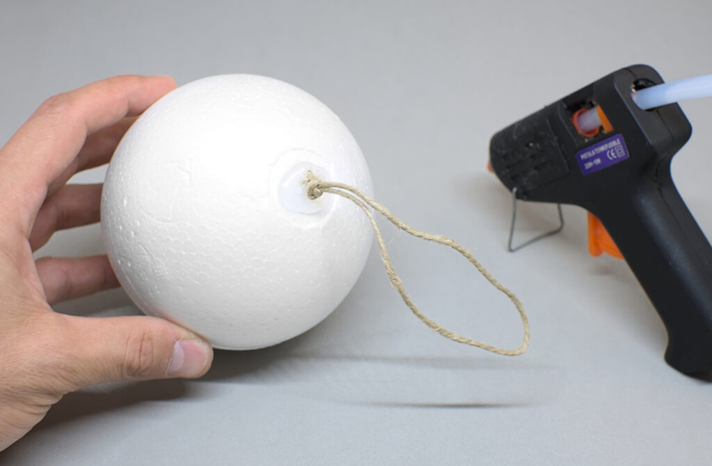 bola de porexpan con cuerda adherida para hacer colgador