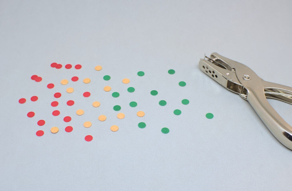 pequeños circulos de cartulinas de colores hechos con perforadora de papel