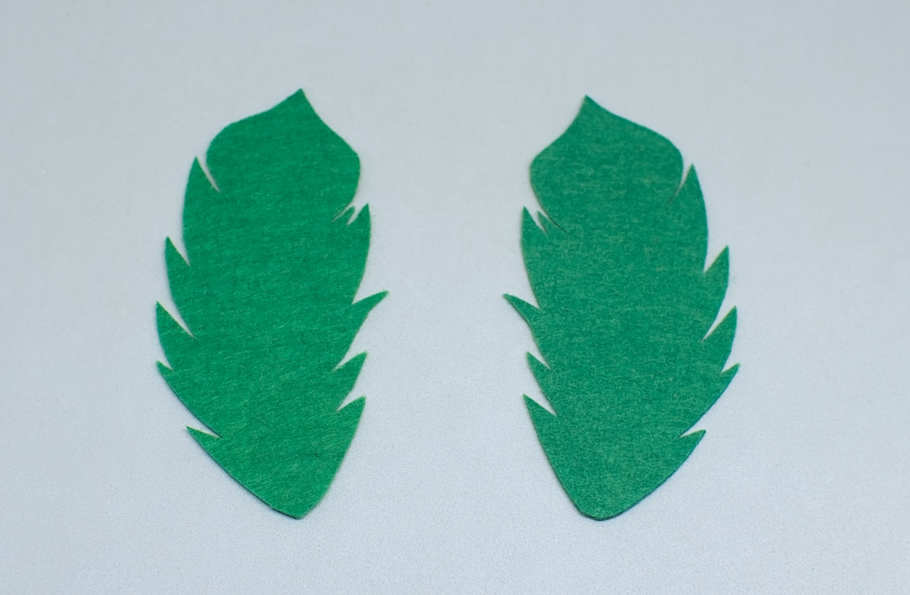 dos piezas de fieltro de color verde con forma de pluma