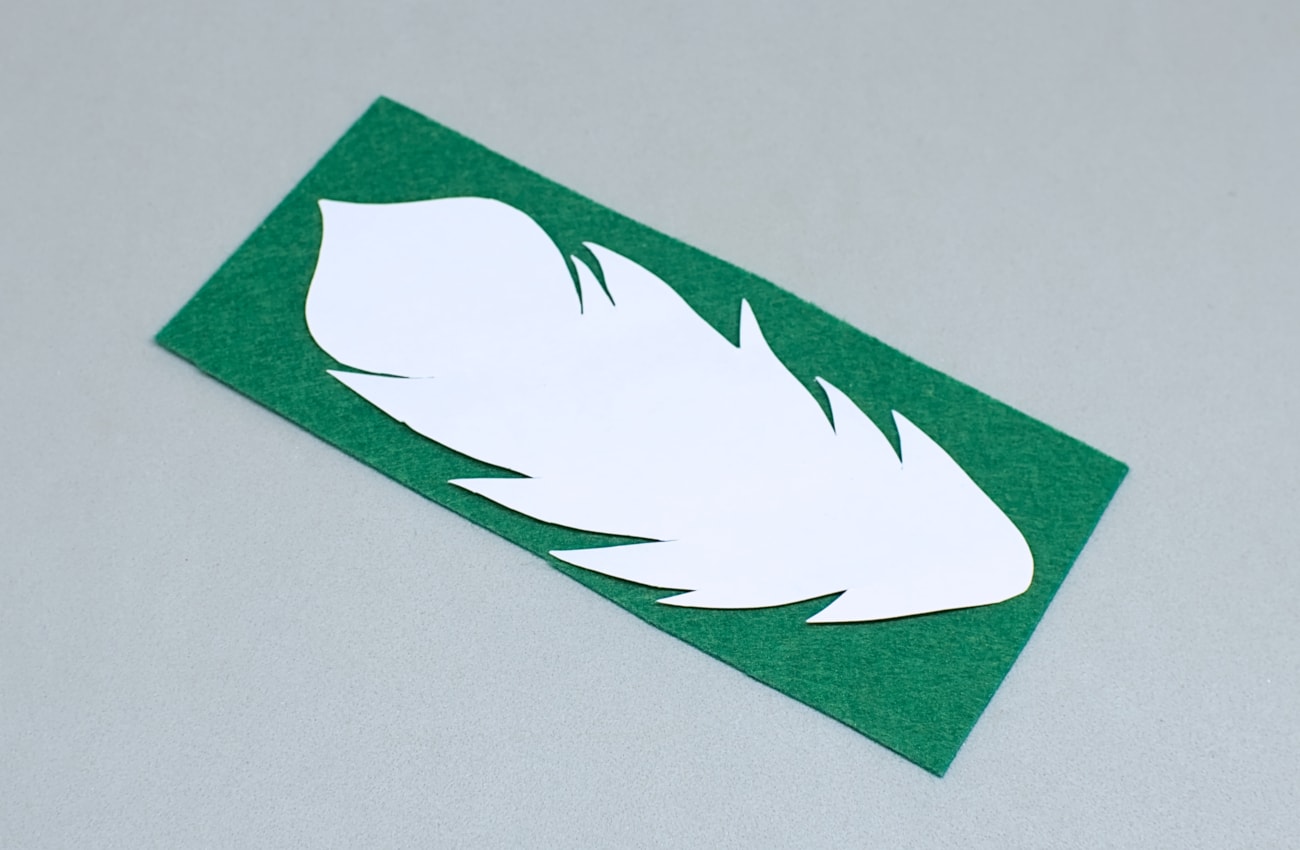 plantilla en papel de pluma sobre fieltro verde
