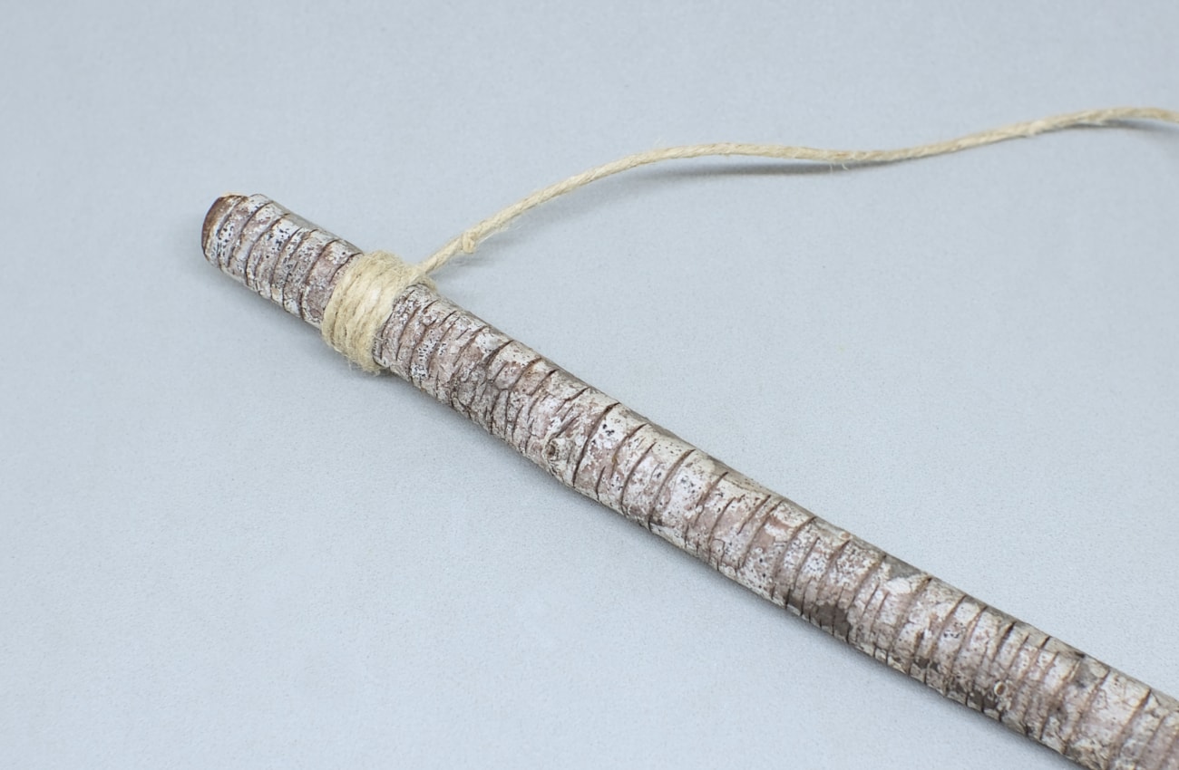 rama seca de pino con cuerda de yute anudada en un extremo