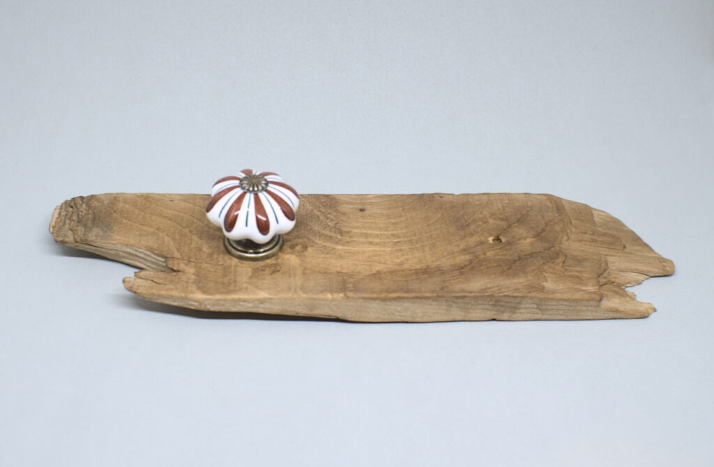 fragmento de madera de deriva con pomo de porcelana