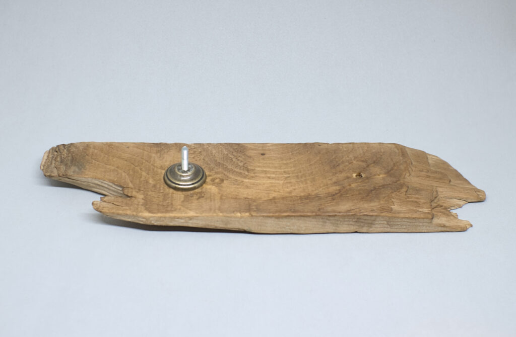 fragmento de madera de deriva con tornillo y pieza de laton