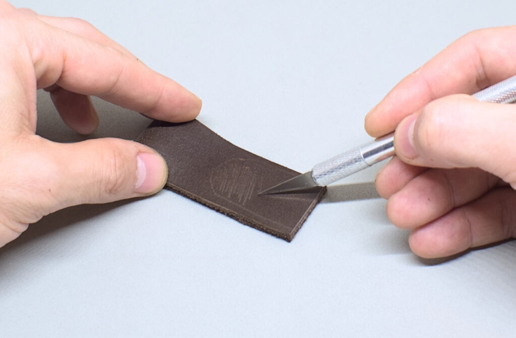 raspando superficie lisa de pasador de cuero marron oscuro