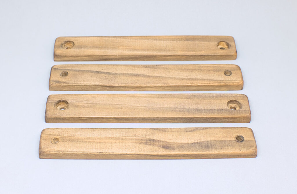 cuatro listones de madera envejecidos con betun de judea