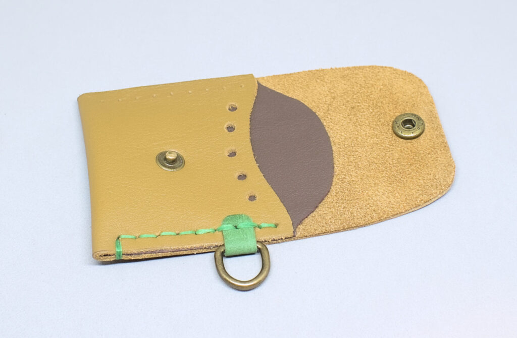 costura recta en un lateral del monedero de cuero