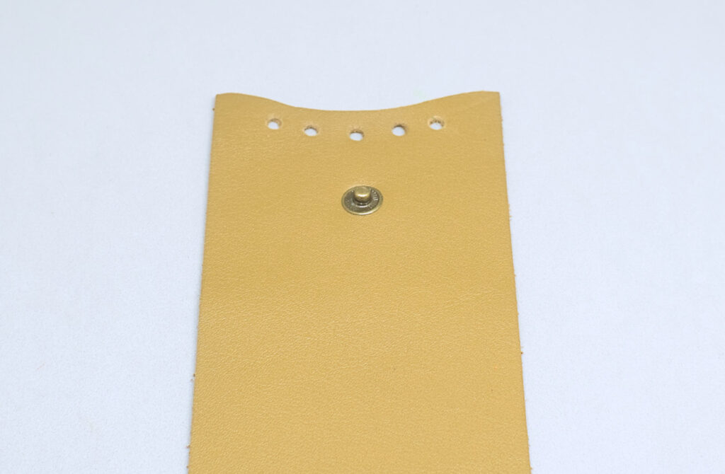 pieza principal de cuero para monedero con orificios decorativos y boton a presion