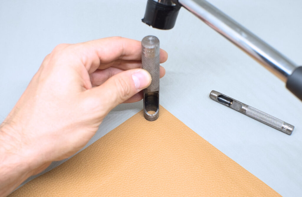 haciendo perforaciones en retal de cuero con sacabocados