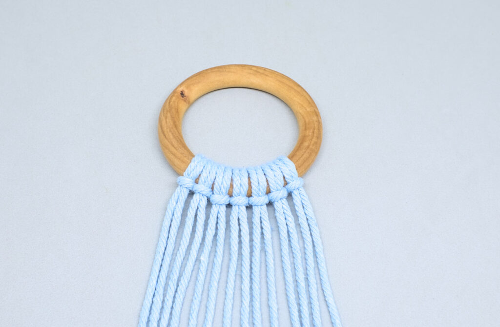 tiras de cordon de algodon anudadas con nudo de alondra en aro de madera