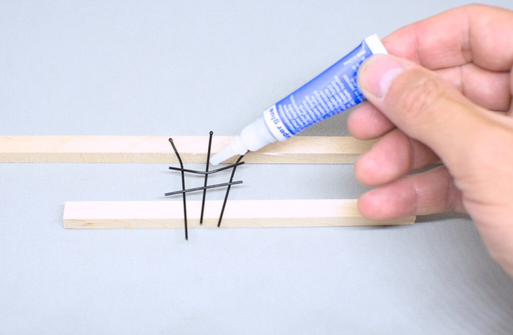 adhiriendo pequeñas barras de horquillas con pegamento de cianoacrilato