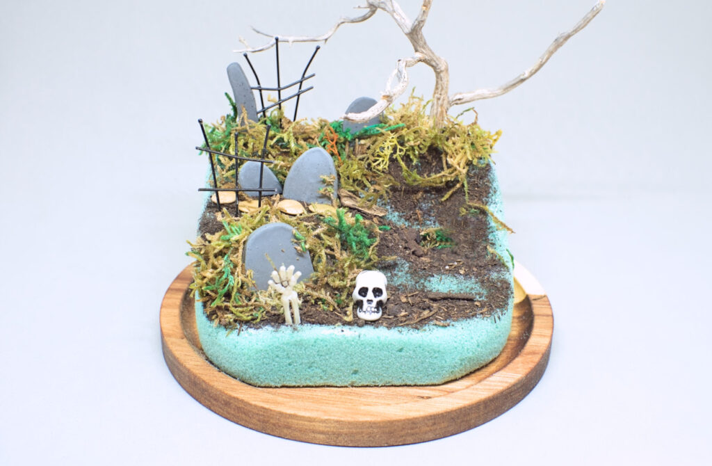 colocando musgo natural de diferentes colores en diorama de halloween