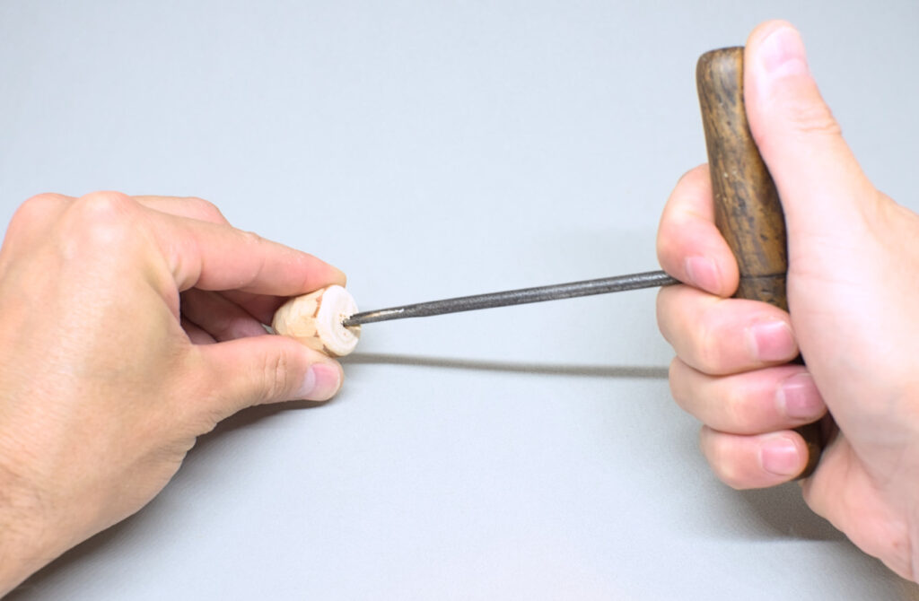 perforando cara plana de sombrero de seta de madera con barrena de mano