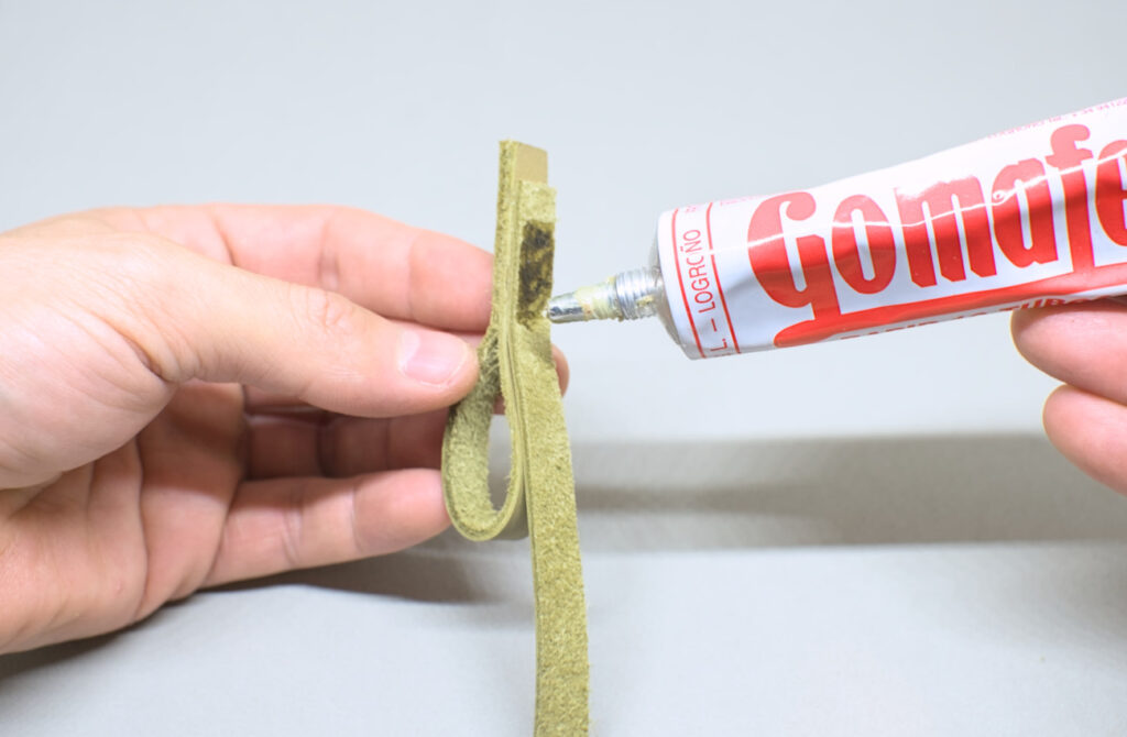 adhiriendo en lateral de lagrima una tira de cuero verde oliva