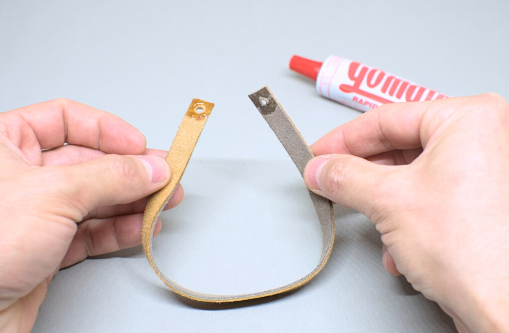 adhiriendo extremos de tira de cuero con orificios