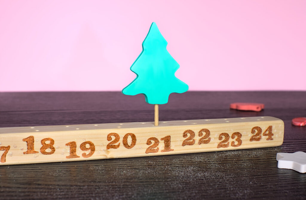 calendario de adviento hecho con plastilina y un liston de madera