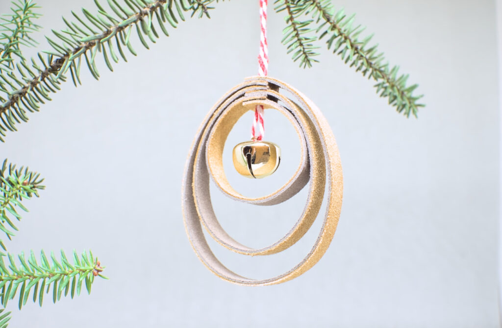 colgante de navidad con forma de bola hecho con tiras de cuero cerradas