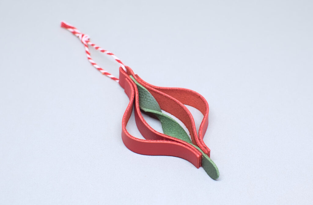 colgante de navidad con forma de peonza hecho con tiras de cuero