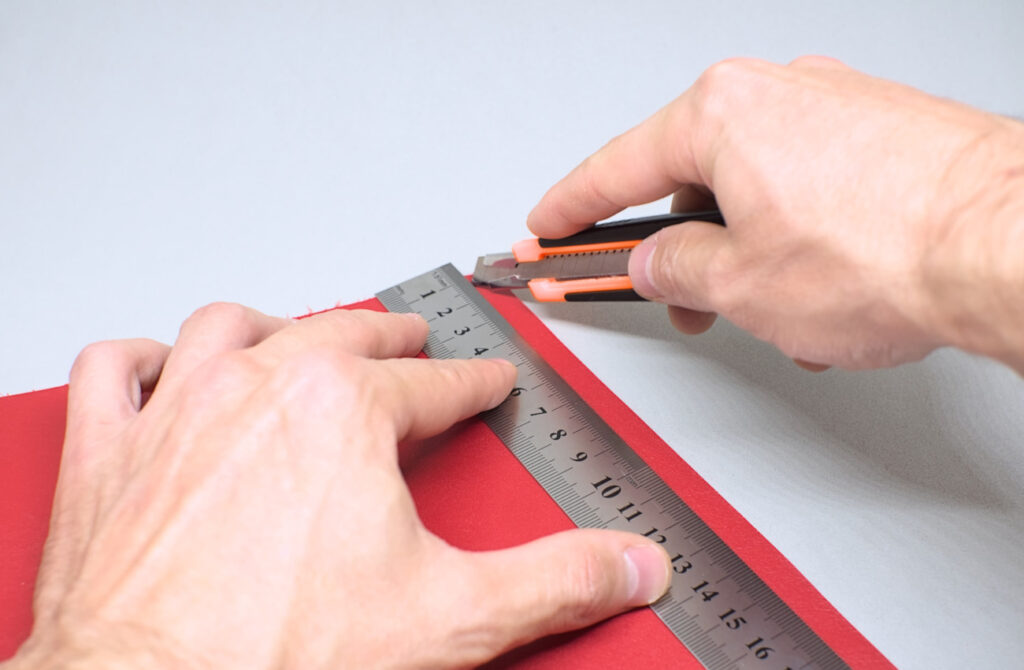 cortando tiras de cuero en color rojo