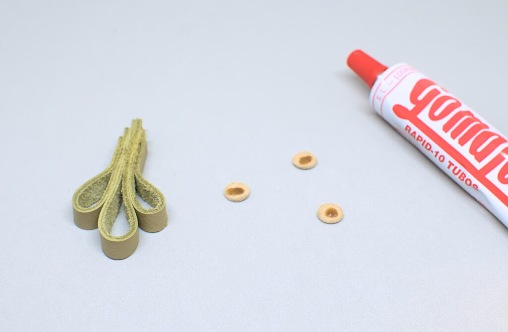 echando pegamento de contacto en pequeños circulos de cuero