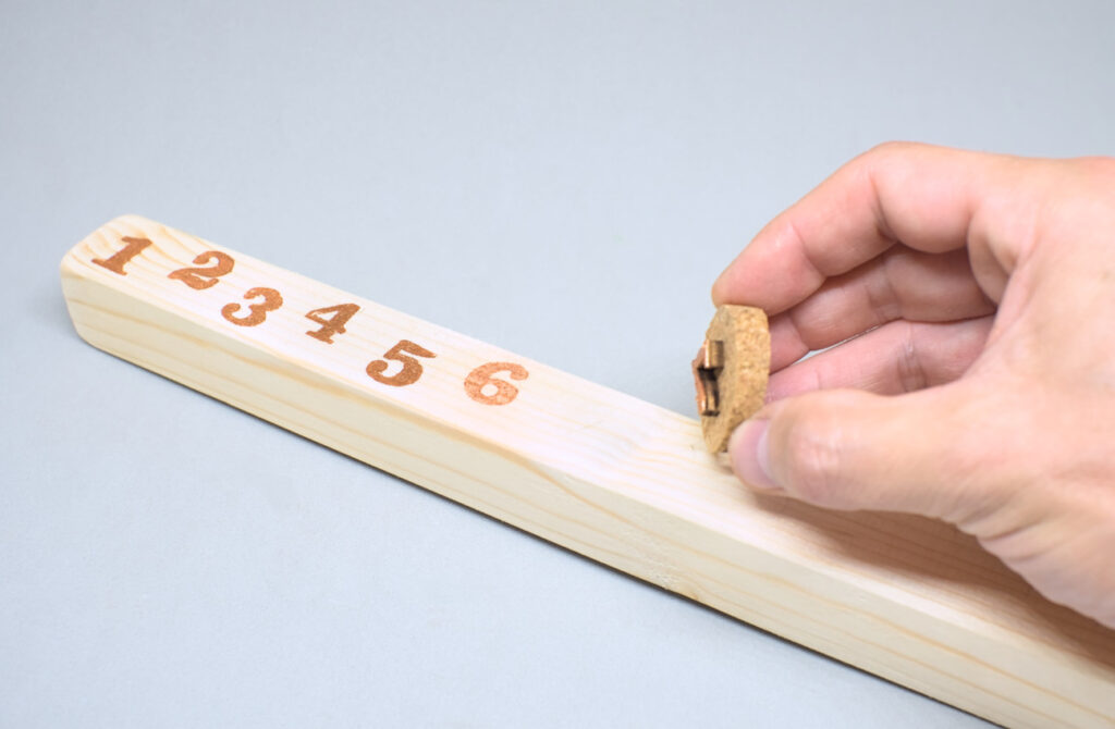 estampando numeros sobre madera con sellos caseros y pintura acrilica