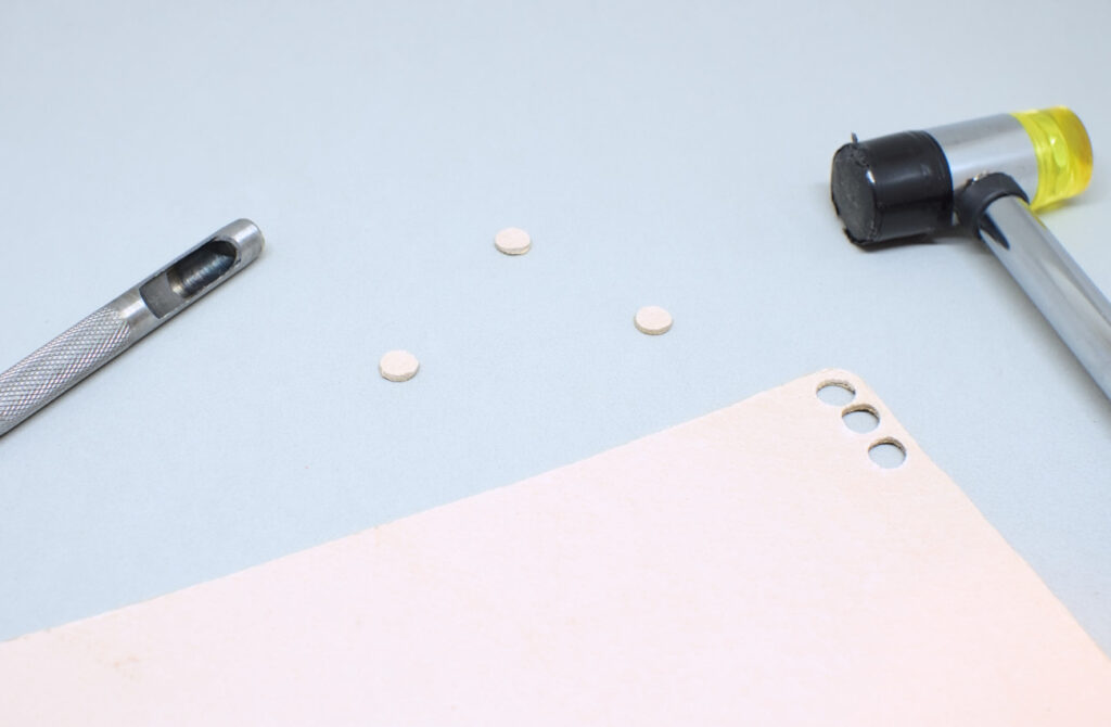 pequeños circulos de cuero beige cortados con sacabocados