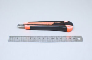 regla de metal y cuter