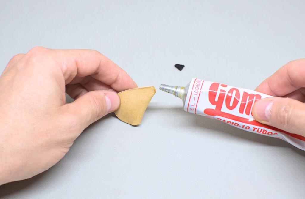 adhiriendo pieza de cuero negra para hacer bota de vino en miniatura