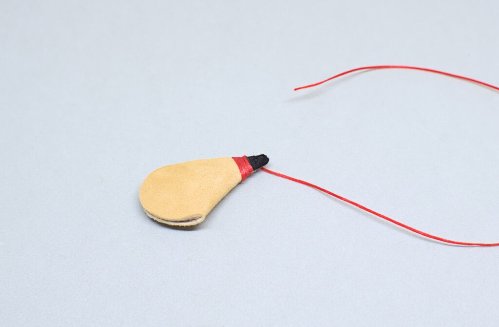 envolviendo cuello de mini bota de vino con hilo encerado rojo