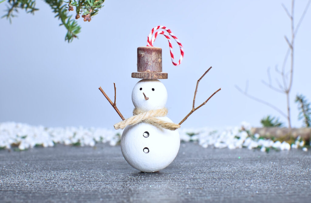 muñeco de nieve hecho con madera para colgar en el arbol de navidad
