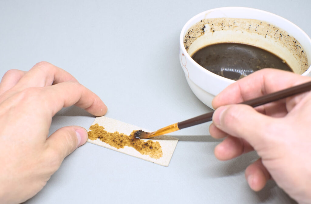 tiñiendo pieza de carton con cafe