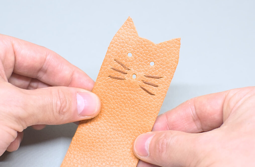 bigotes de gato cosidos en pieza de cuero